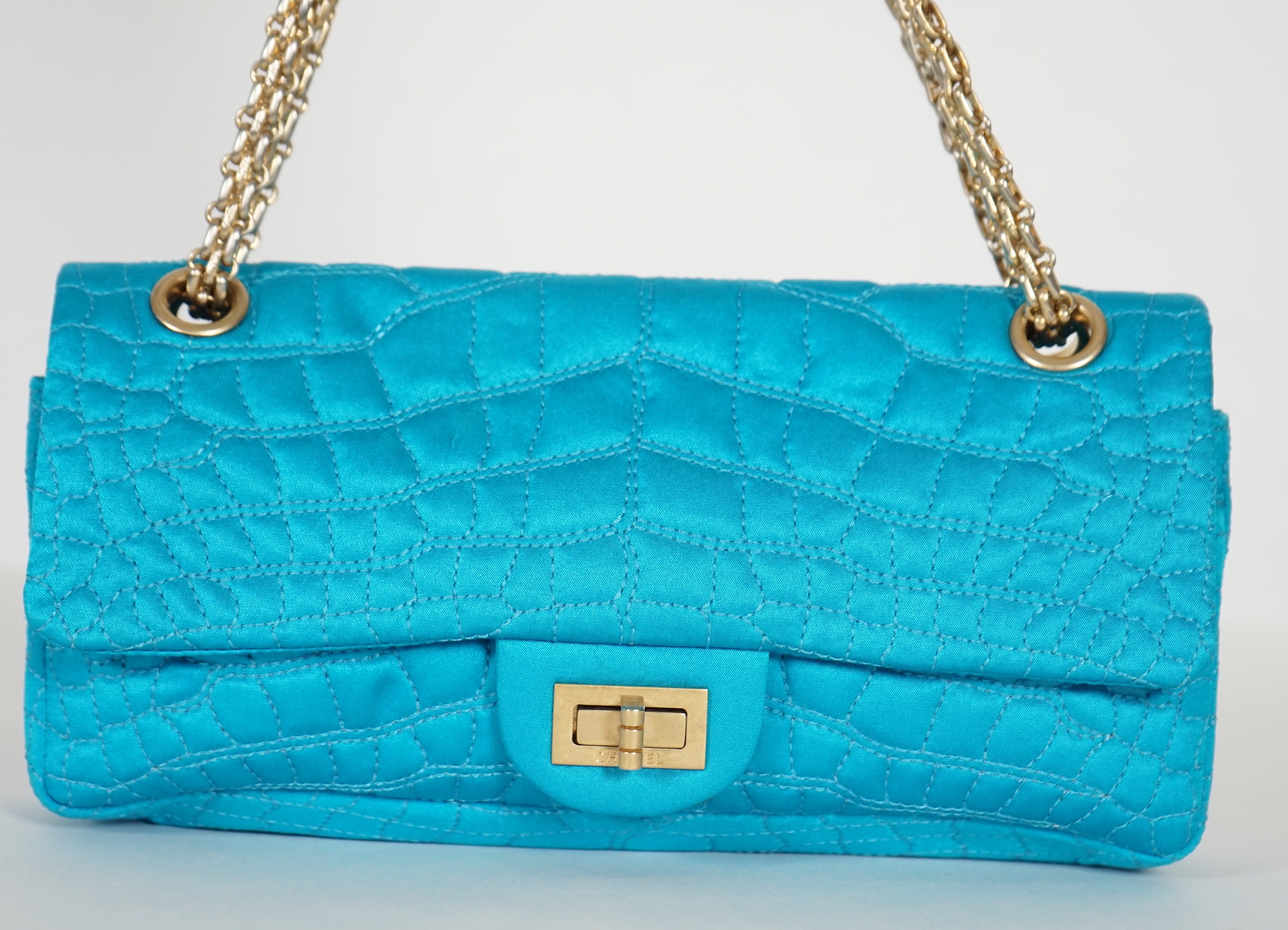 A Chanel medium-sized 2-55 bag in turquoise blue silk satin stitched with a quilted crocodile pattern, width 24cm, height 15cm, depth 6cm, Single handle 112cm, Double handles 65cm